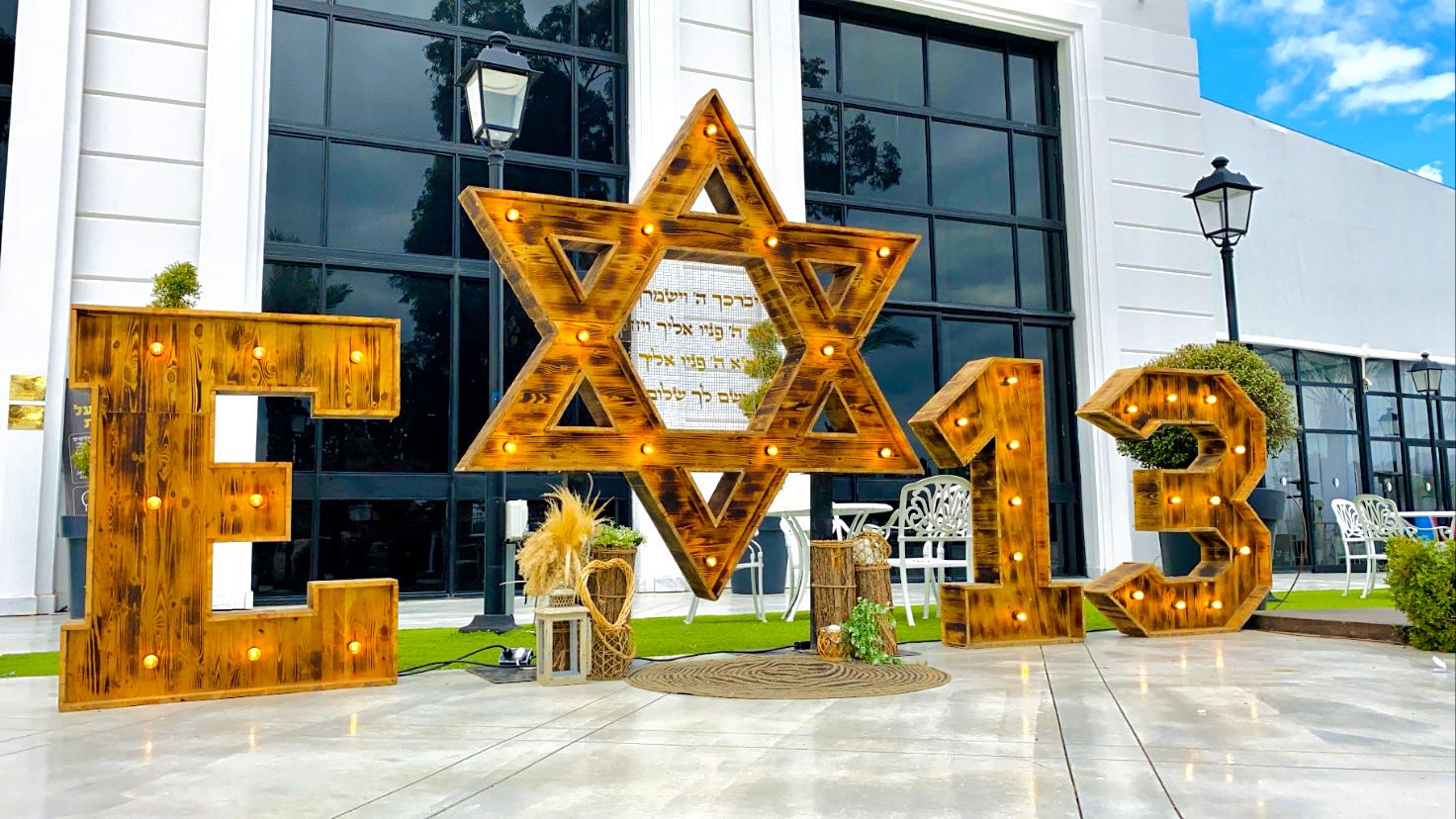 אותיות מעץ עם מגן דוד, מחזיקי מפתחות ללא הגבלה, קופים מרקדים, קיאק פירות, זיקוקים בכניסה, עשן כבד ויער בלונים לסלואו 3